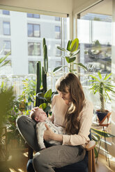 Mother looking at her newborn baby boy at home - MFF03570