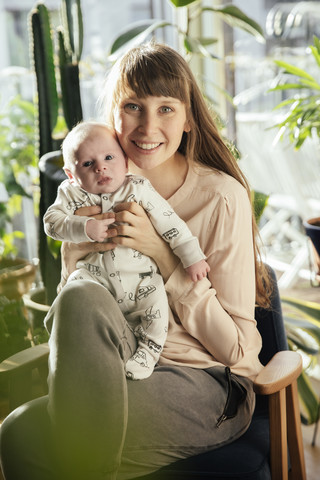 Mutter hält ihr neugeborenes Baby zu Hause, lizenzfreies Stockfoto