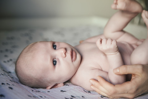 Mother caressing her naked newborn baby boy on changing table stock photo