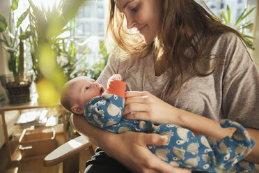 Mother caressing her newborn baby boy at home - MFF03578