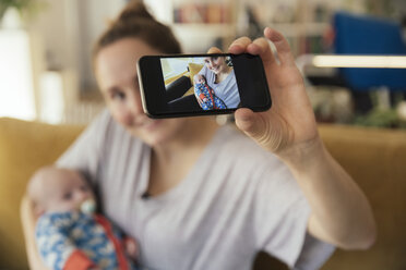 Mother taking a selfie with her newborn baby at home - MFF03585