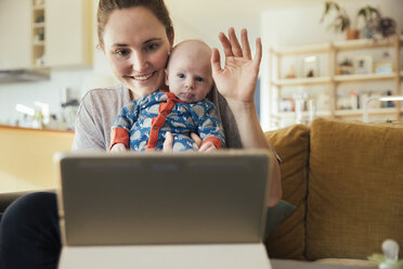 Mother and newborn baby taking a video call at home - MFF03586