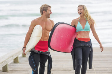 Couple walking from beach with surfboards - ZEF13856