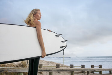 Frau am Meer mit Surfbrett genießt die Aussicht - ZEF13873