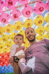 South Korea, Gyeongju, father with a baby girl under colorful paper lanterns at Bulguksa Temple - GEMF01646