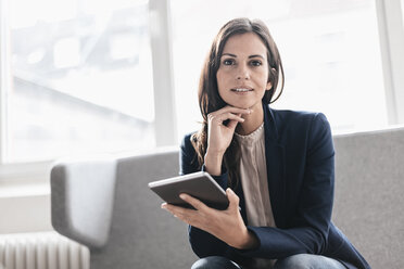 Portrait of confident businesswoman with tablet on couch - JOSF00955