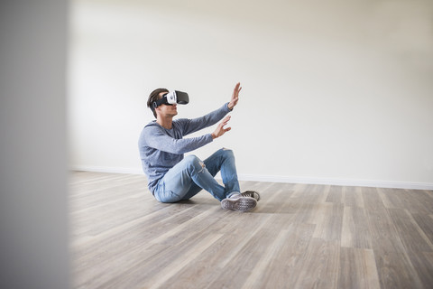 Mann in leerer Wohnung mit VR-Brille, lizenzfreies Stockfoto