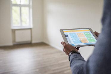 Man in new home using tablet with smart home apps - UUF10725