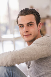 Portrait of smiling young man in new home - UUF10751