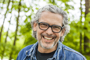 Portrait of laughing man with grey hair and beard wearing glasses - TCF05411