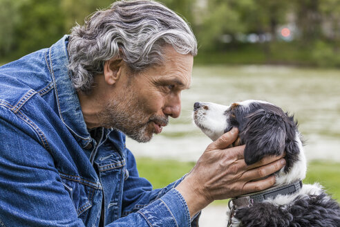 Älterer Mann im Gespräch mit seinem Hund - TCF05415