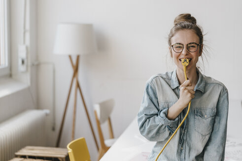 Portrait of happy young woman with power cable - KNSF01483