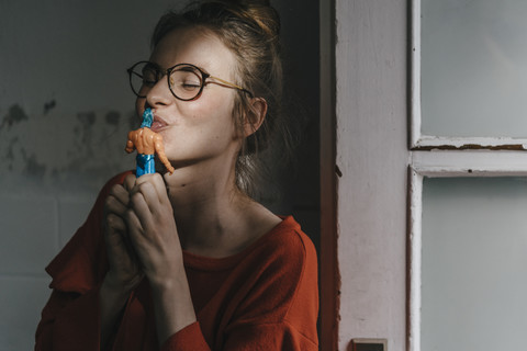 Junge Frau küsst Superhelden-Comic-Figur, lizenzfreies Stockfoto