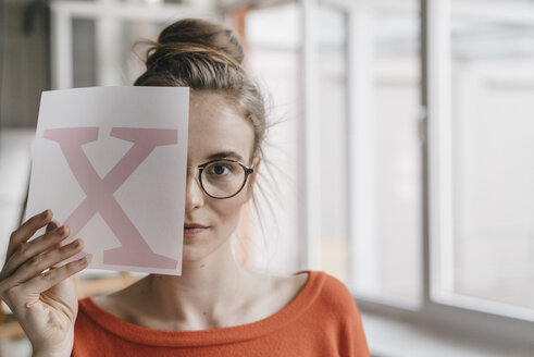 Portrait of young woman holding letter x template - KNSF01498