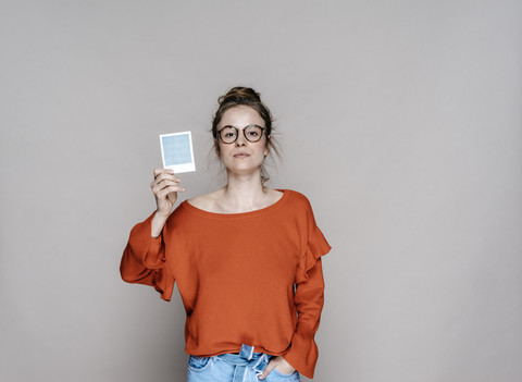 Porträt einer jungen Frau mit einem Sofortbild, lizenzfreies Stockfoto