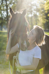 Young woman with horse at backlight - TCF05421