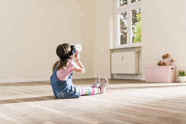 Mädchen in leerer Wohnung mit VR-Brille - UUF10766