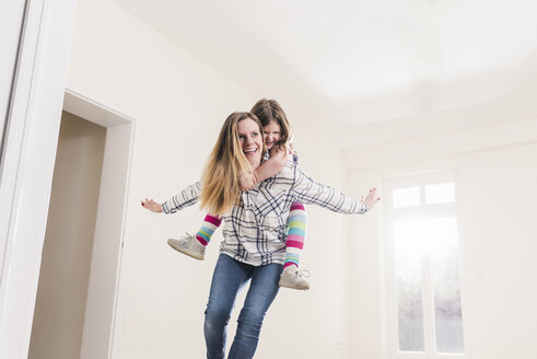 Happy mother and daughter in empty apartment - UUF10770