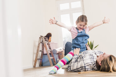 Glückliche Mutter und Tochter spielen im neuen Haus - UUF10779