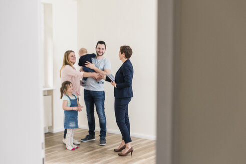 Immobilienmakler und Familie in neuer Wohnung - UUF10794