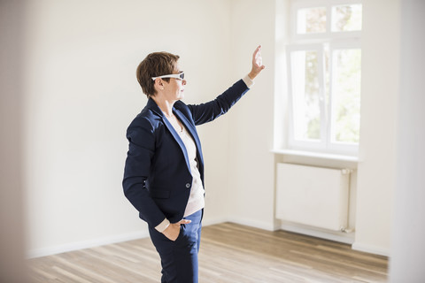 Frau in leerer Wohnung mit Smartglasses, lizenzfreies Stockfoto