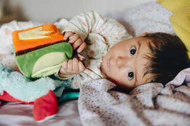 Baby girl playing with toys in partent's bed - GEMF01653