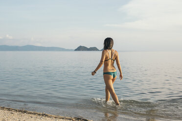 Back view of woman walking at seaside - MOMF00171