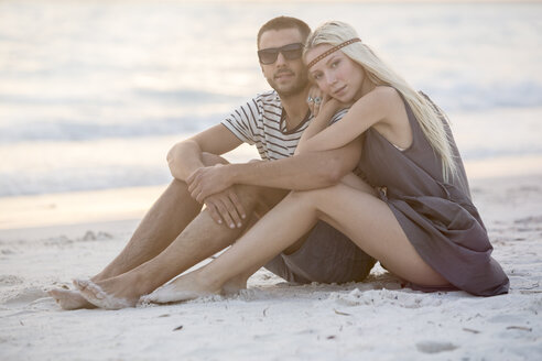 Junges Paar am Strand sitzend, sich umarmend - ZOCF00423