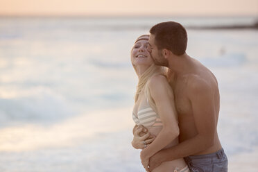 Romantic couple kissing on the beach - ZOCF00427