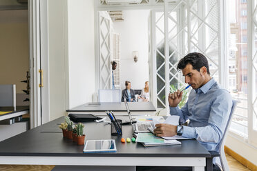 Geschäftsmann arbeitet im Büro und liest Papiere - JRFF01362