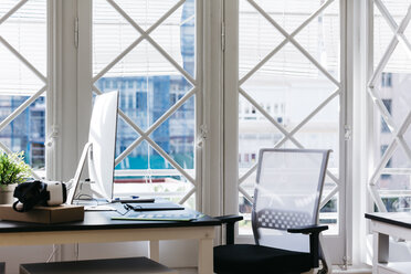 Interior of a modern office, VR glasses and computer on desk - JRFF01386