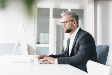 Geschäftsmann arbeitet im Büro am Computer - JOSF00988