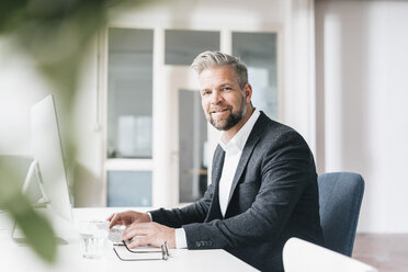 Geschäftsmann arbeitet im Büro am Computer - JOSF00989