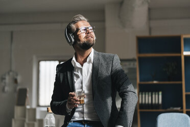 Businessman wearing head phones , listening music - JOSF01012