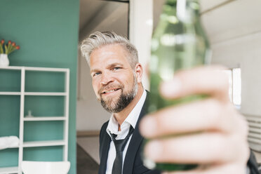 Businessman toasting with bottle of beer - JOSF01021