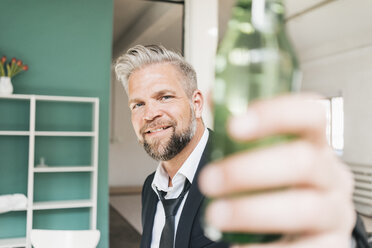 Geschäftsmann stößt mit einer Flasche Bier an - JOSF01021