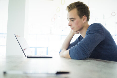 Besorgter Schüler schaut auf seinen Laptop - JOSF01037