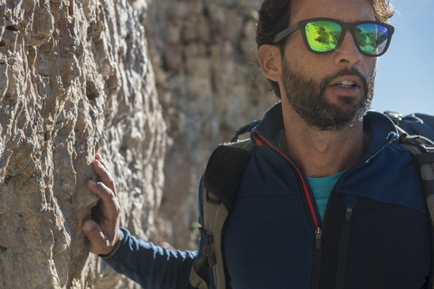 Italien, Dolomiten, mittlerer erwachsener Mann beim Wandern in den Bergen mit Sonnenbrille, lizenzfreies Stockfoto