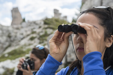 Italien, Dolomiten, Frau beobachtet die Natur durch ein Fernglas - ZOCF00481