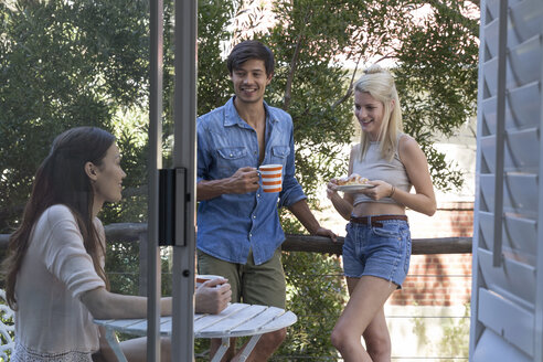 Lächelnde Freunde beim Kaffee auf der Veranda - WESTF23179