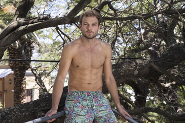 Portrait of young man in swimming trunks outdoors - WESTF23240