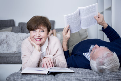 Älteres Paar liegt auf der Couch und liest Bücher - WESTF23275