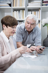 Senior couple with bills and calculator checking their expenses - WESTF23281