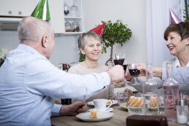 Zwei ältere Paare feiern Geburtstagsparty, stoßen mit Rotwein an - WESTF23286