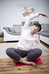 Senior woman practicing yoga at home - WESTF23328