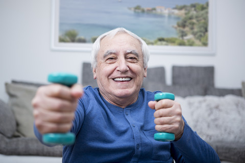 Älterer Mann beim Muskeltraining zu Hause, lizenzfreies Stockfoto