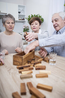 Group of seniors having a games evening at home - WESTF23366