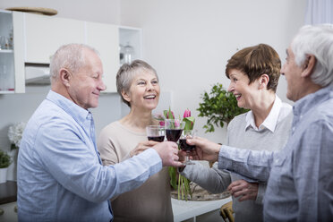 Two senior couples celebrating, toasting with red wine - WESTF23377
