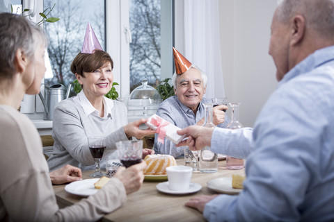 Two senior couples celebrating birthday party, toasting with red wine stock photo