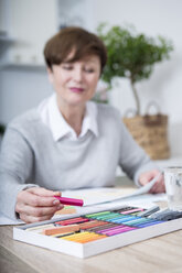 Senior woman drawing picture with crayons - WESTF23396